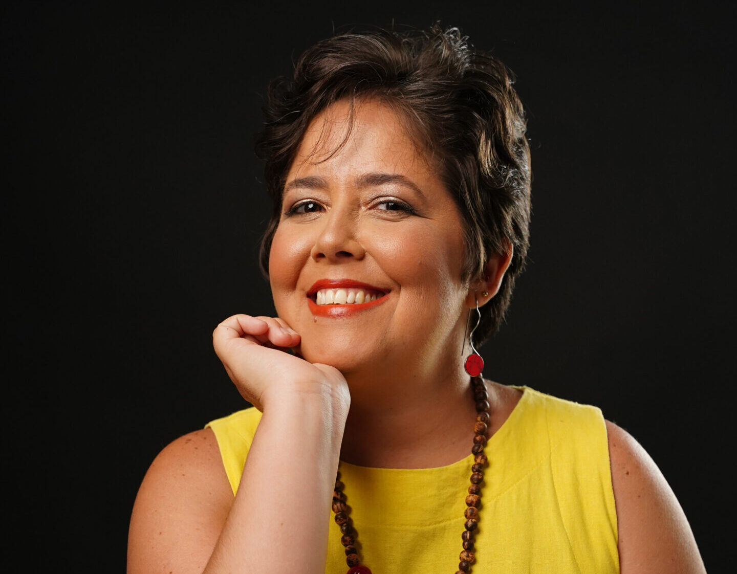 Renata Leite em vestido amarelo e colar vermelho